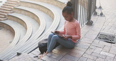 Girl Using Tablet for Online Learning on School Steps