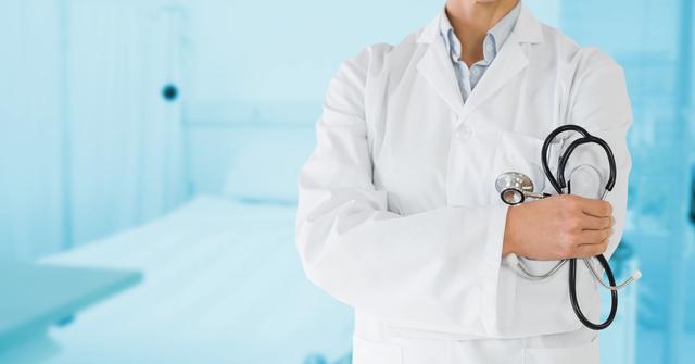 Doctor standing in hospital room holding stethoscope. Ideal for healthcare, medical services, hospital advertisements, and professional healthcare presentations.