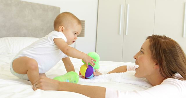 Mother and Baby Playing on Bed with Toys in Bedroom - Download Free Stock Images Pikwizard.com