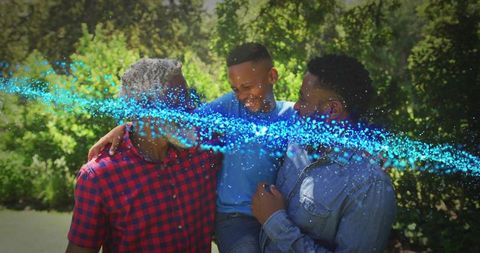 African american family laughing and holding child with blue light particle trail