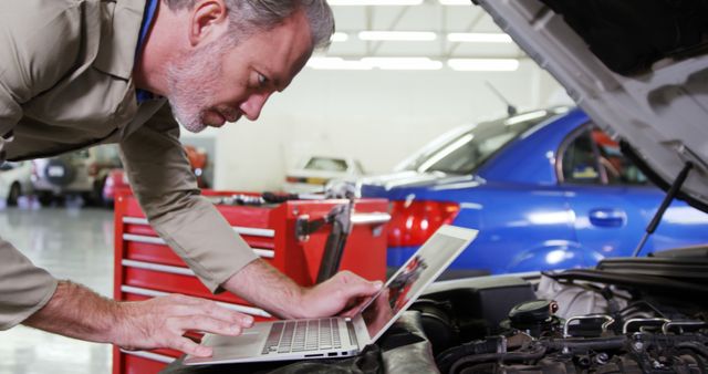 Mechanic Using Laptop for Car Engine Diagnostics in Workshop - Download Free Stock Images Pikwizard.com