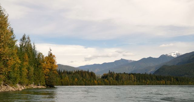 This serene river landscape with autumnal trees and mountains exudes nature's tranquility. - Download Free Stock Photos Pikwizard.com