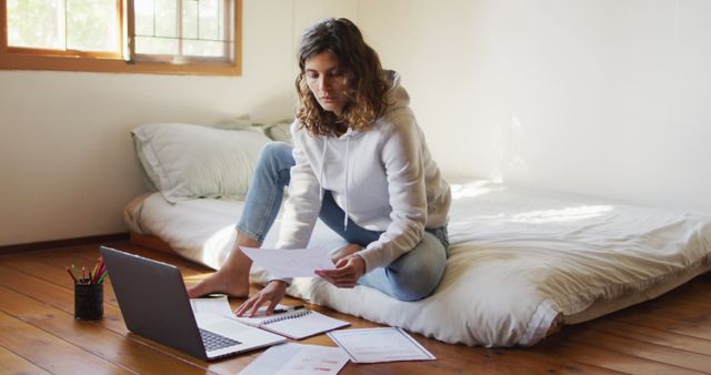 Young Woman Managing Finances at Home on Laptop and With Documents - Download Free Stock Images Pikwizard.com