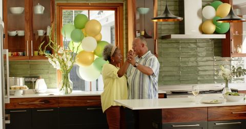 Senior Couple Dancing in Bright Kitchen on Special Occasion