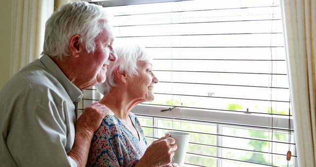 Senior couple looking out from the window at home - Download Free Stock Photos Pikwizard.com