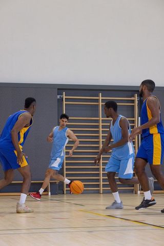 Diverse Athletes Playing Intense Indoor Basketball Game