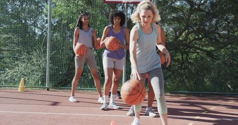 Diverse Women Practicing Basketball Dribbling Outdoors
