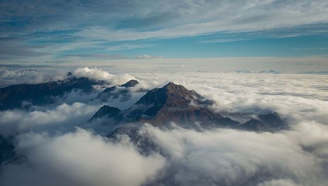Rugged Mountain Peak Rising Above Majestic Clouds