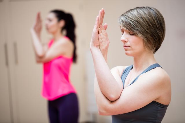 Women practicing yoga hand exercises focusing on concentration and relaxation. Ideal for use in articles or promotions related to wellness, meditation, yoga classes, physical fitness, and balanced lifestyles. Suitable for illustrating the mental and physical benefits of yoga and other meditative practices.