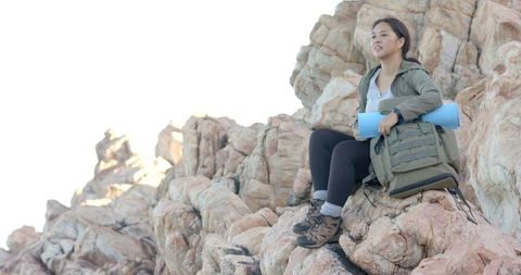 Woman Unpacking Backpack on Rocky Mountain Adventure