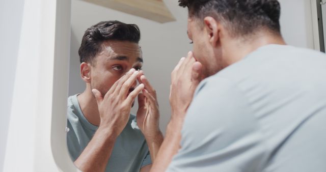 Man Applying Moisturizer in Front of Bathroom Mirror - Download Free Stock Images Pikwizard.com