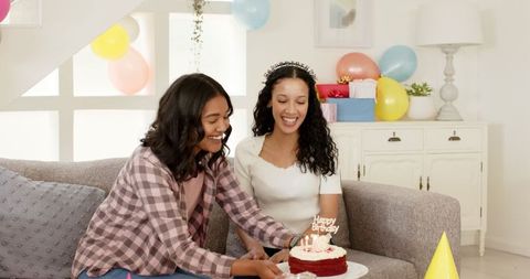 Women's Joyful Birthday Celebration with Cake and Balloons