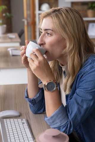 Businesswoman Enjoying Coffee at Workspace Desk