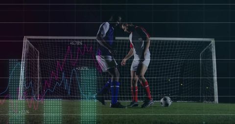 Two soccer players facing off in front of goal at night with performance analytics overlay