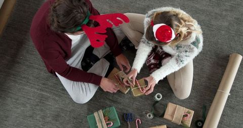 Festive friends wrapping holiday gifts collaborative and cozy atmosphere