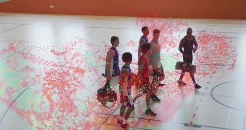 Walking basketball players carrying duffel bags across indoor court with confetti overlay