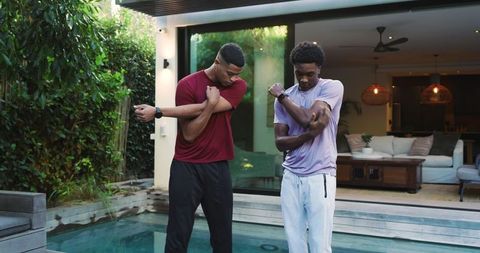 Diverse Friends Stretching with Smartwatches Beside Pool