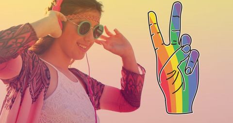Joyful young woman dancing with rainbow peace sign icon