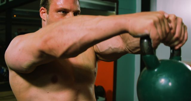 Muscular man lifting kettlebell in gym 4k