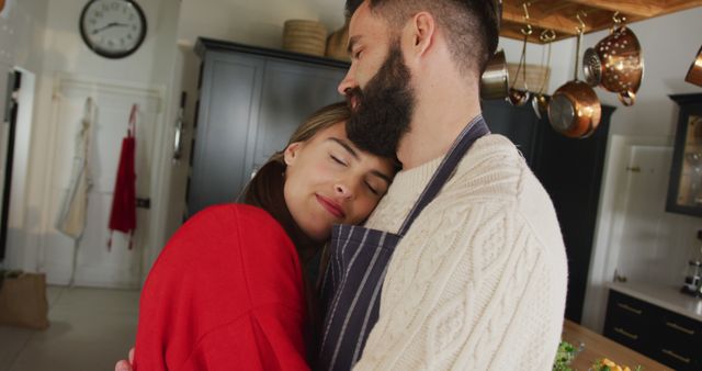 Loving couple embracing warmly in a cozy kitchen setting, enjoying a moment of tranquility. This heartwarming image conveys feelings of affection, warmth, and domestic bliss. Ideal for use in advertisements for home and lifestyle products, articles on relationships, and content celebrating love and companionship.
