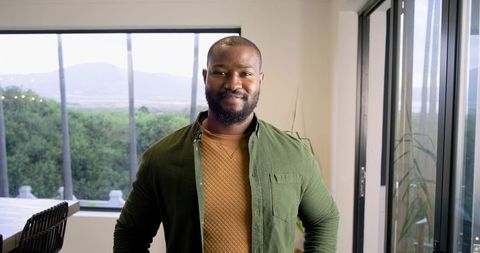 Confident African American Man Standing in Modern Minimalist Interior with Natural Light