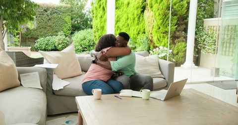 Mature couple embracing during financial planning at home