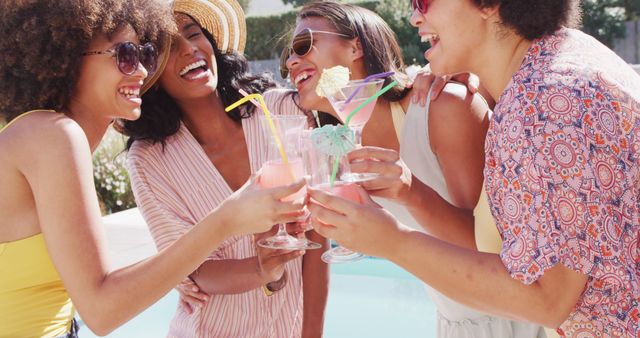 Happy diverse female friends talking and drinking drinks in garden together. healthy and active time holiday.