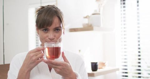 Middle-Aged Woman Relaxing with a Warm Cup of Tea at Home