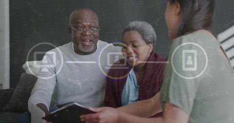 Senior couple consulting advisor reviewing documents and tablet with virtual interface