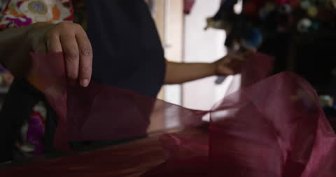 Artisan Crafting Hat with Fabric at Workshop Table