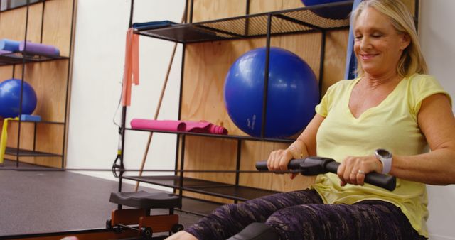 Smiling Senior Woman Exercising on Rowing Machine in Modern Gym - Download Free Stock Images Pikwizard.com