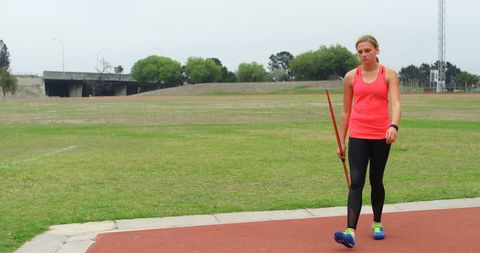 Female athlete preparing for javelin throw on sports field