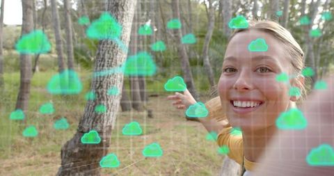 Smiling woman pointing at augmented cloud grid in forest using smartphone for cloud computing