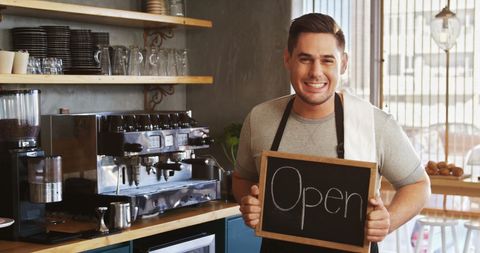 Smiling Cafe Owner Displaying 'Open' Sign - Download Free Stock Images Pikwizard.com