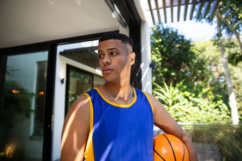 Athletic Young Man Relaxing Outdoors with Basketball