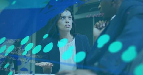Executive woman leading data-driven discussion with colleague in modern fintech boardroom