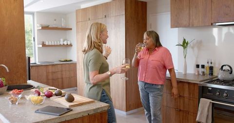 Diverse Female Friends Enjoying Wine and Culinary Prep in Modern Kitchen
