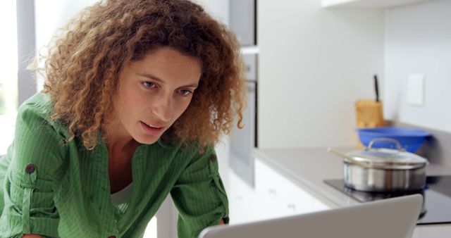 Woman with Curly Hair Working on Laptop in Kitchen - Download Free Stock Images Pikwizard.com