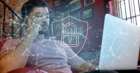 Cybersecurity Concept with Individual Using Laptop and Smartphone Indoors