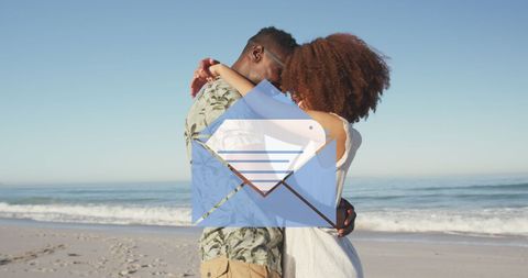 Romantic couple embracing on beach with digital email icon overlay