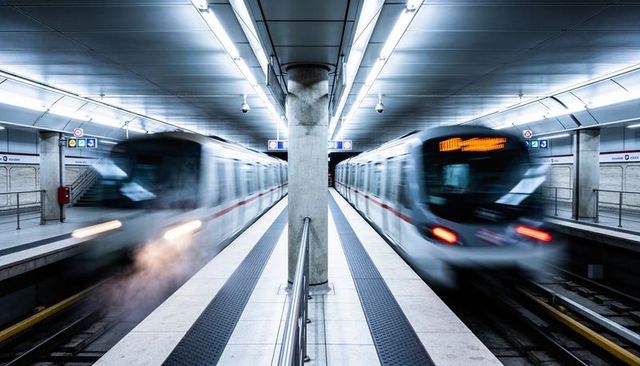 Symmetric underground metro motion blur featuring central concrete column on platform