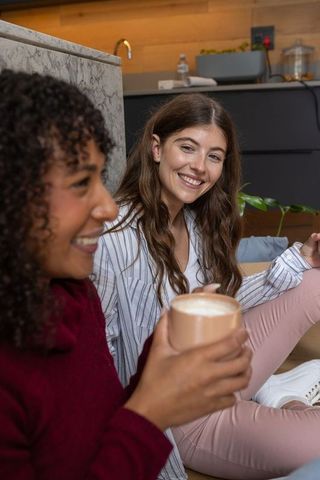 Diverse Female Friends Enjoying Coffee and Conversation in Modern Kitchen