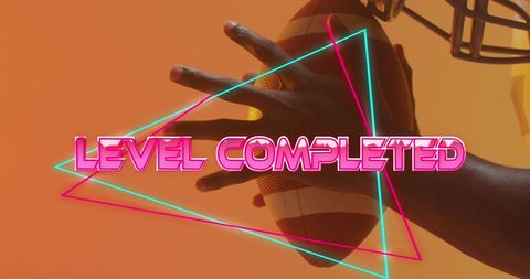 African American Hand Gripping Football with Neon Level Completed Text