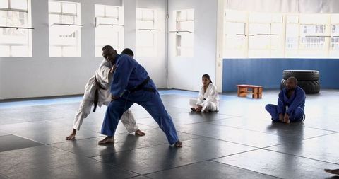 Martial arts students practicing grapples in dojo