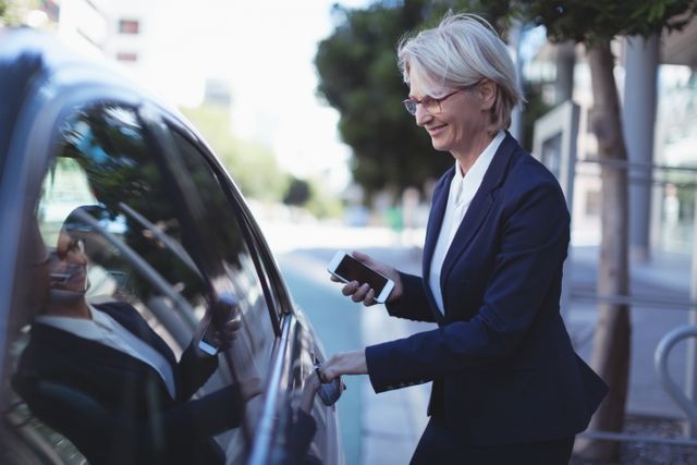 Smiling businesswoman opening car door