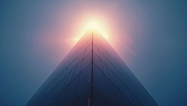 Futuristic Skyscraper with Glowing Apex Light and Lens Flare