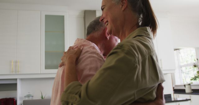 Caucasian senior couple dancing together in the kitchen at home. staying at home in self isolation in quarantine lockdown