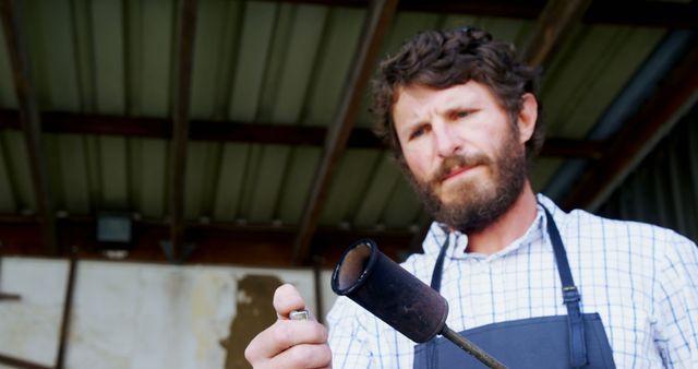 Bearded man in workshop examining metal tool - Download Free Stock Images Pikwizard.com