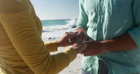 Romantic Beach Couple Holding Hands in Sunlight