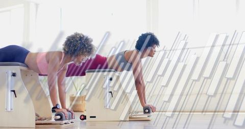 Building core strength: women practicing pilates chair exercises balancing together